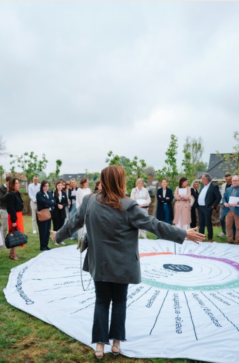 Buitenevenement met groep mensen rond kleed